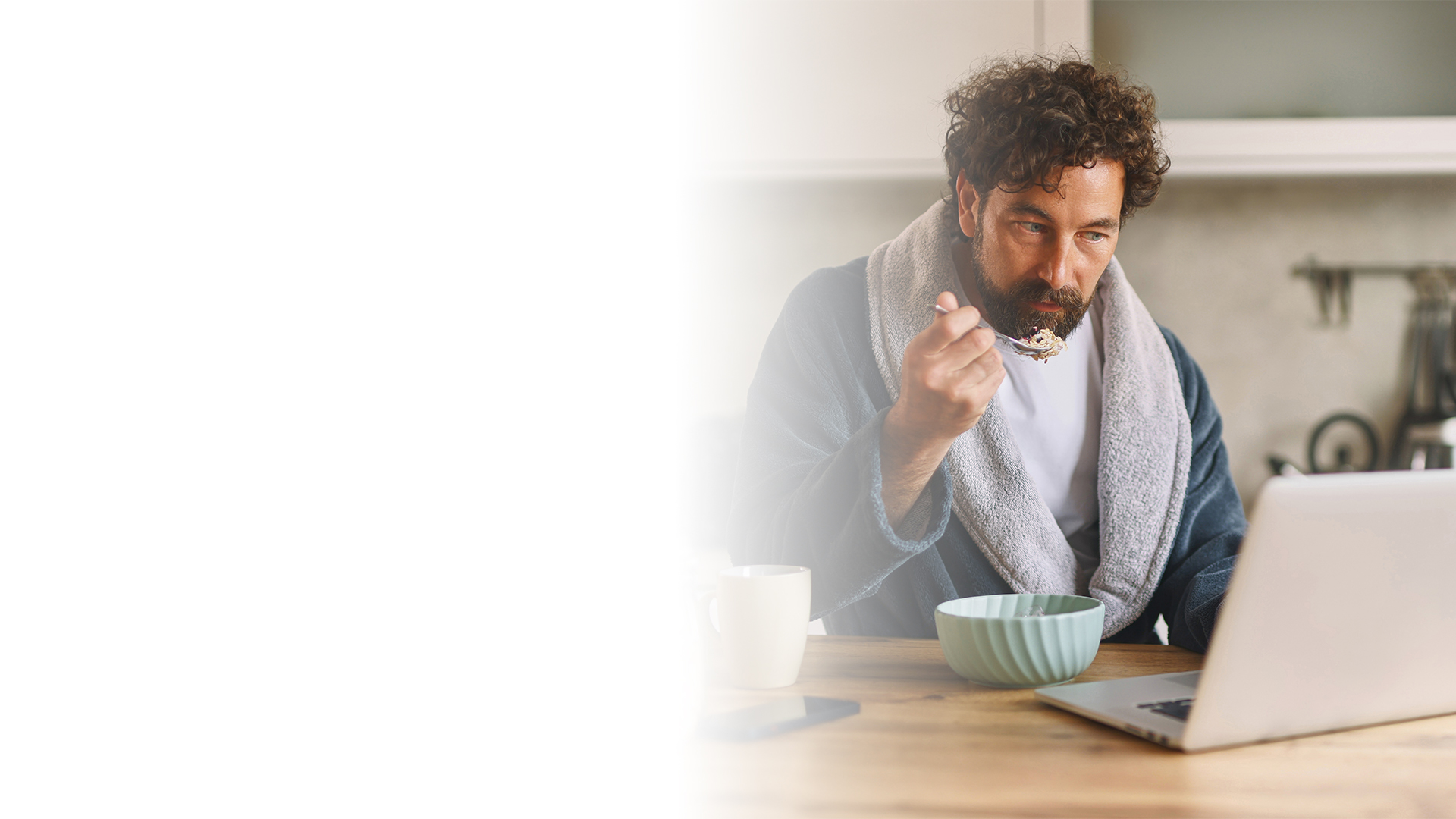 En mann spiser frokost mens han leser