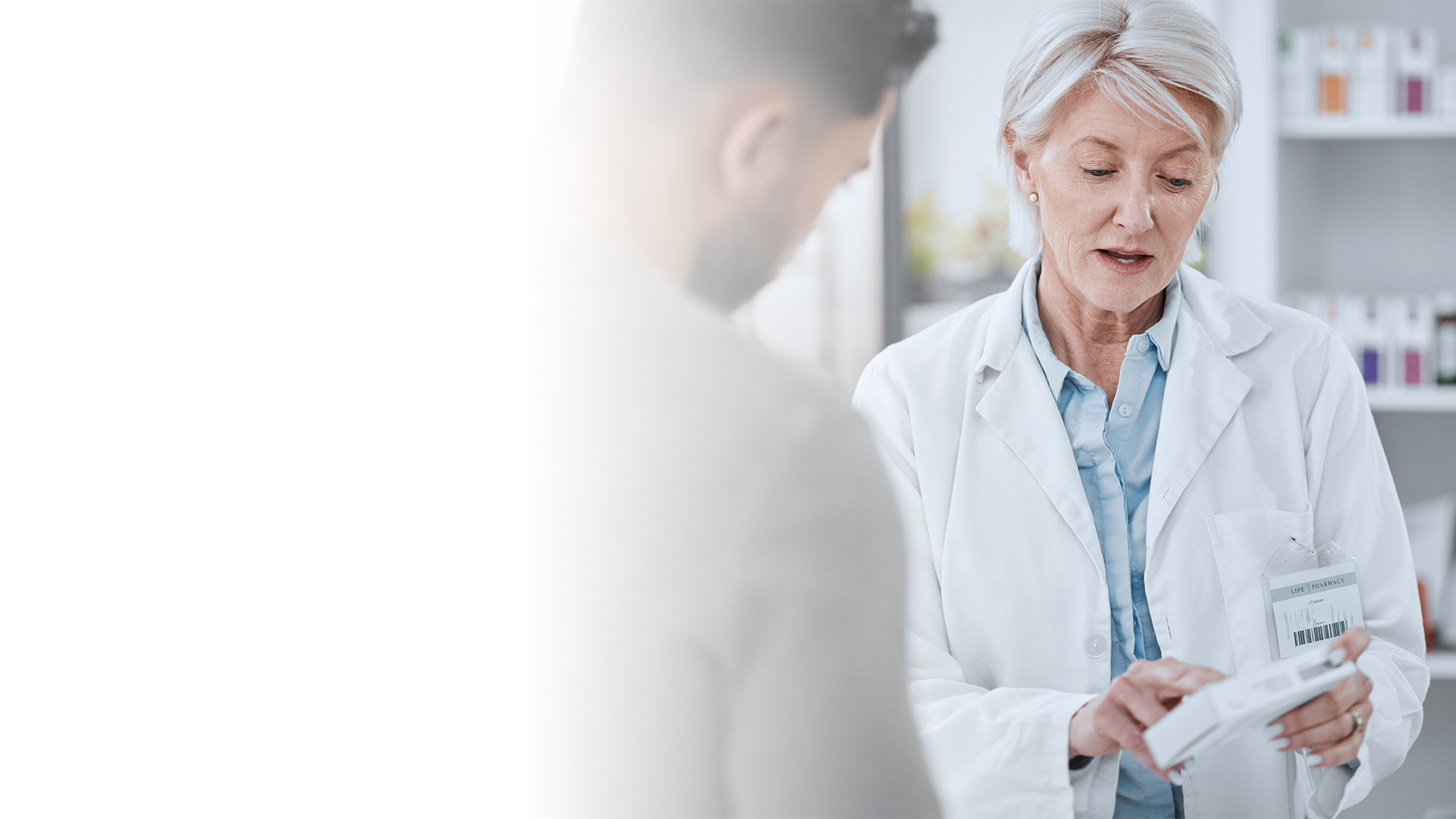 En farmasøyt informerer en kunde om produktet