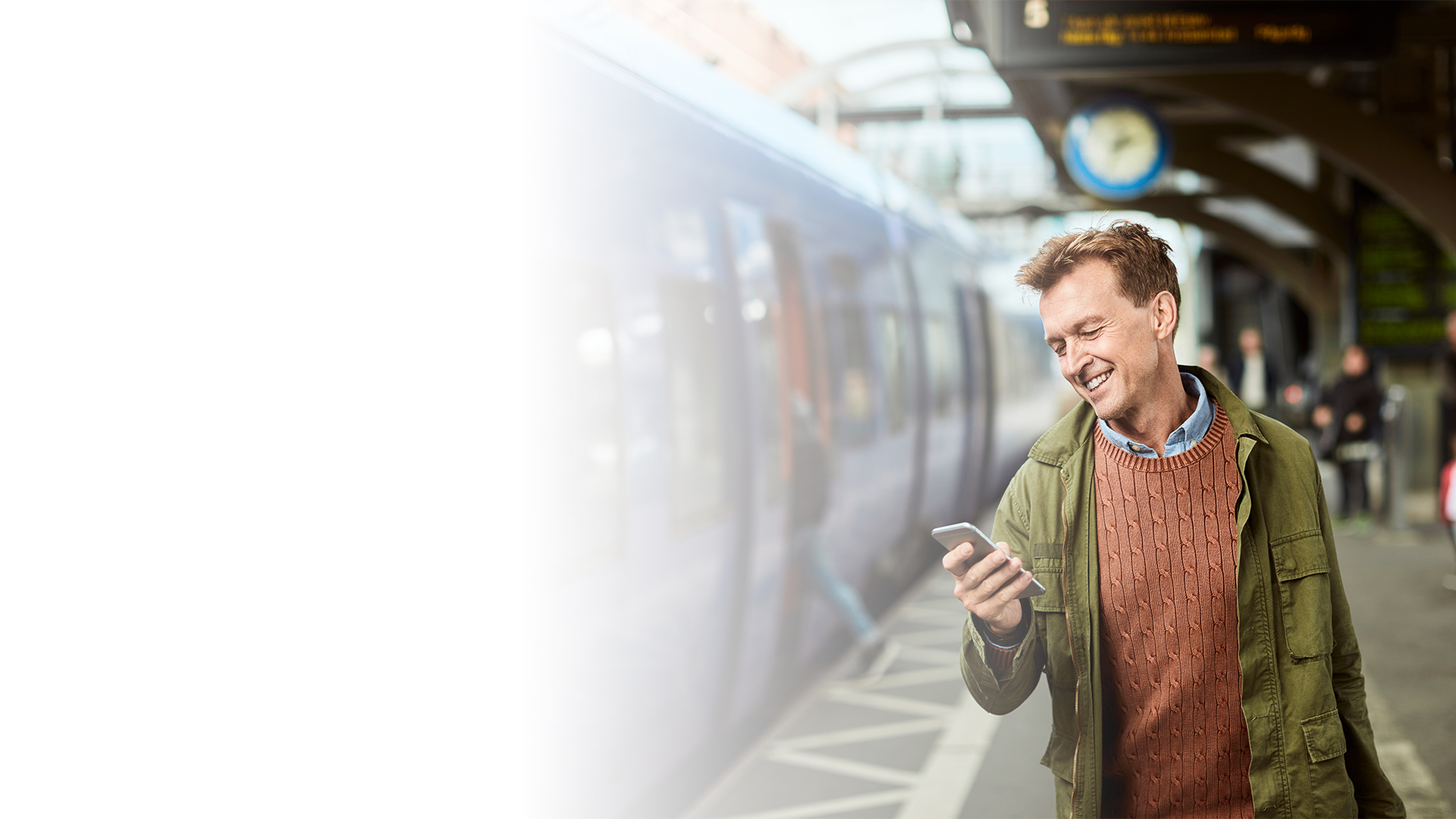 En mann leser på mobiltelefonen sin